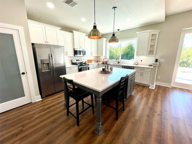 kitchen featuring a wealth of natural light, white cabinetry, and appliances with stainless steel finishes