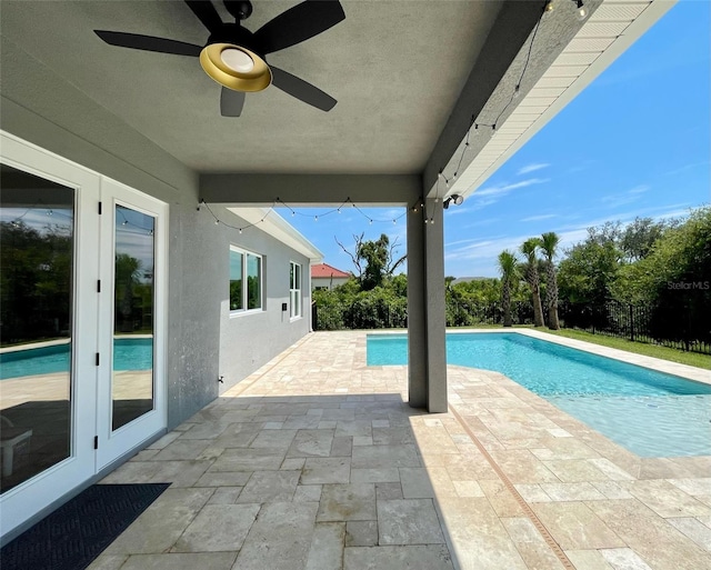 view of swimming pool featuring ceiling fan, french doors, and a patio