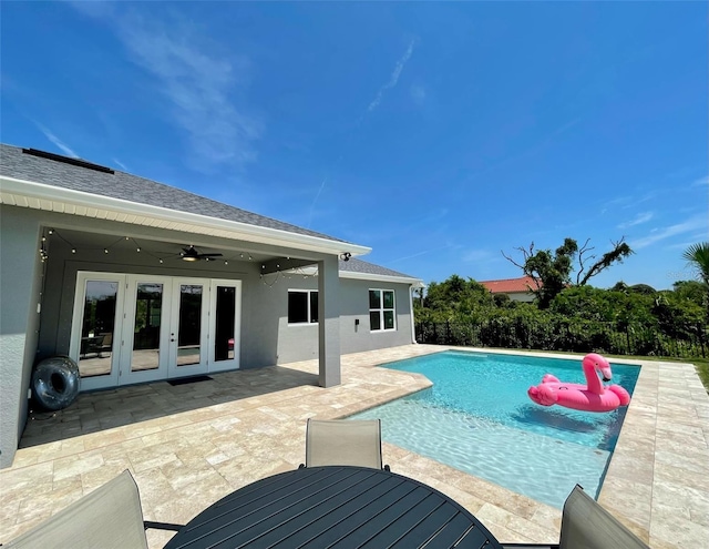 view of swimming pool with ceiling fan, a patio area, and french doors