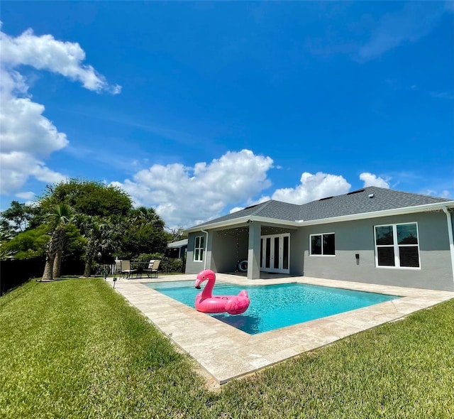 back of property with a lawn and a patio