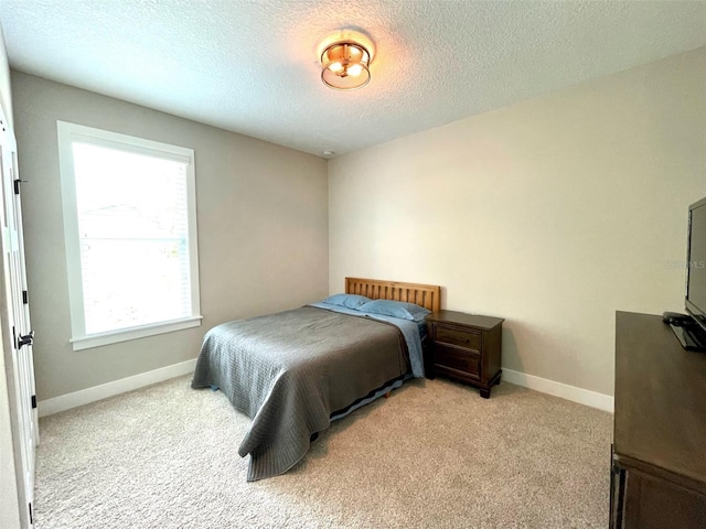 bedroom with light colored carpet and a textured ceiling