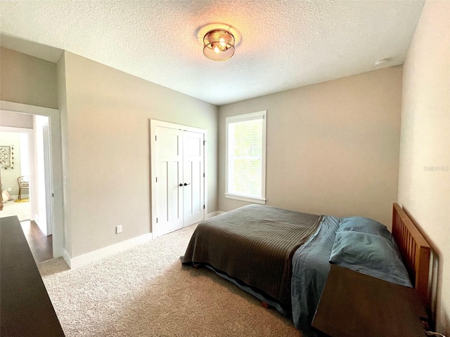 bedroom featuring light colored carpet and a textured ceiling