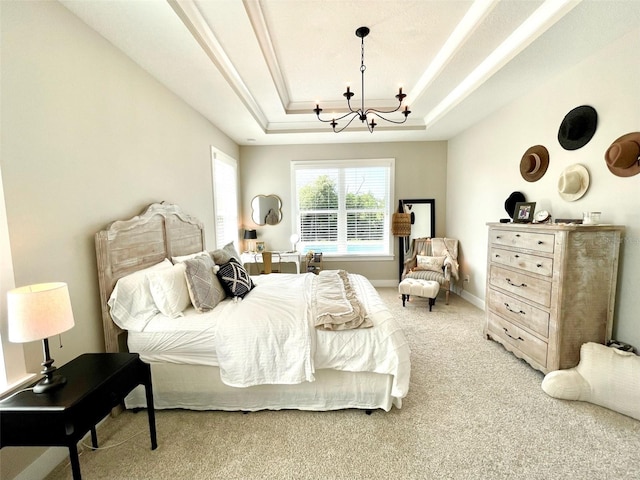 carpeted bedroom featuring a raised ceiling and an inviting chandelier