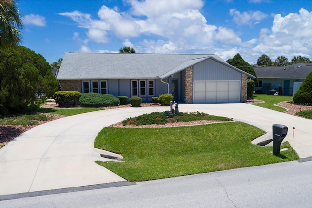 ranch-style home featuring a front lawn, an attached garage, and curved driveway