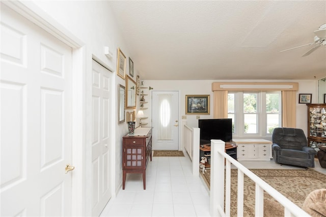 entryway featuring a fireplace, a textured ceiling, and ceiling fan