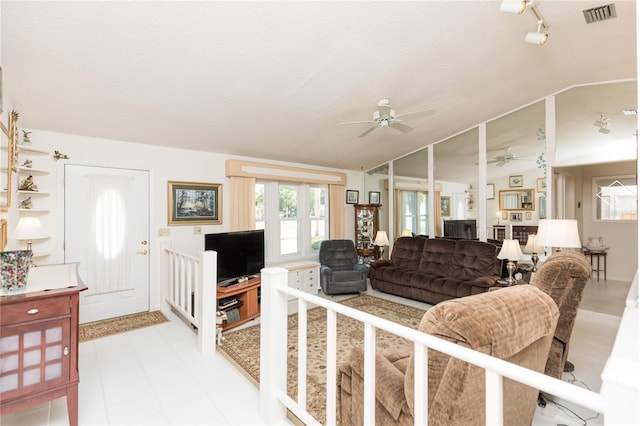 living area with visible vents, a textured ceiling, ceiling fan, and vaulted ceiling