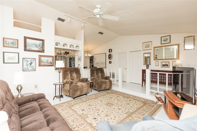 living room featuring a textured ceiling, lofted ceiling, and ceiling fan with notable chandelier