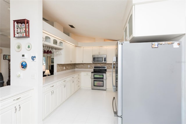 kitchen with visible vents, tasteful backsplash, appliances with stainless steel finishes, light countertops, and lofted ceiling