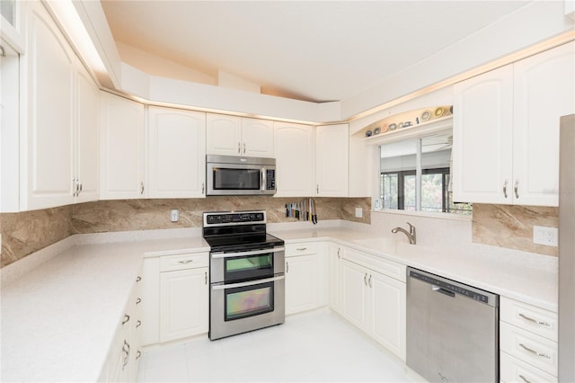 kitchen with tasteful backsplash, appliances with stainless steel finishes, light countertops, and lofted ceiling