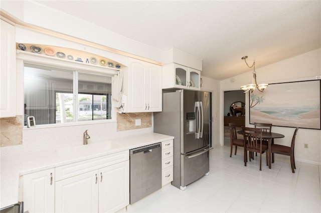 kitchen with stainless steel appliances, sink, white cabinets, backsplash, and pendant lighting