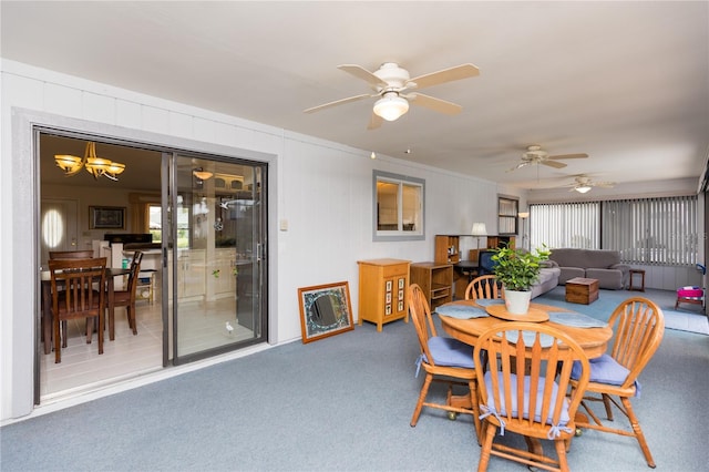 dining room featuring ceiling fan with notable chandelier and carpet floors