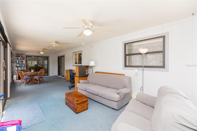 carpeted living room with ceiling fan and crown molding