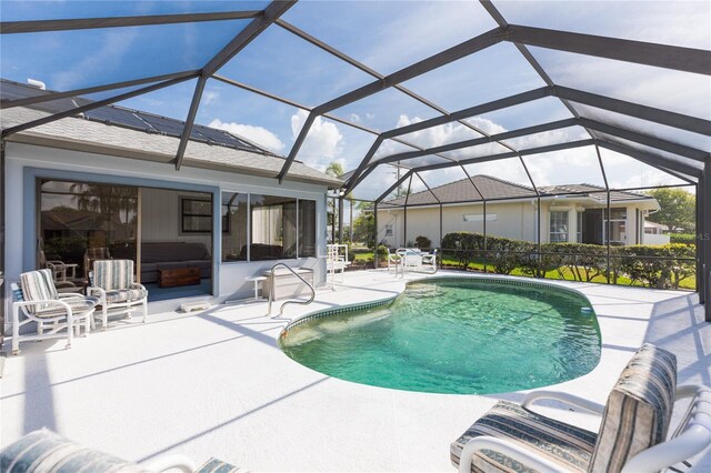 view of swimming pool featuring a lanai and a patio area