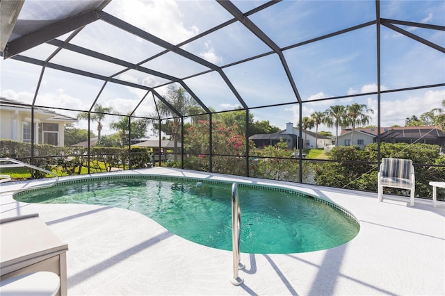 view of swimming pool featuring glass enclosure and a patio