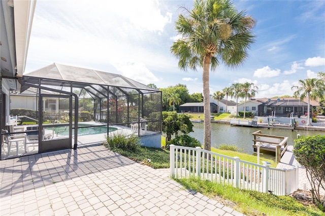 view of patio with glass enclosure and a water view