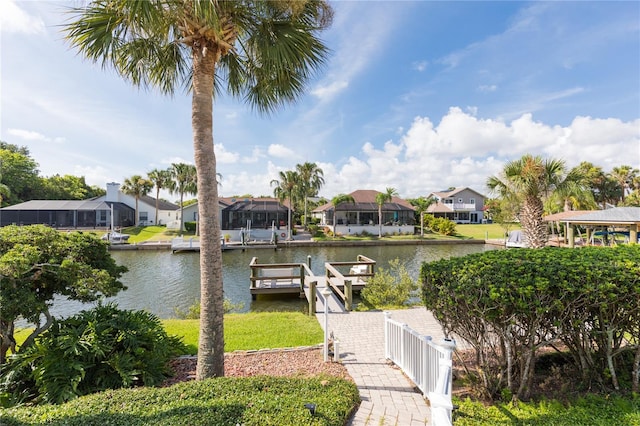 view of dock featuring a residential view, fence, and a water view