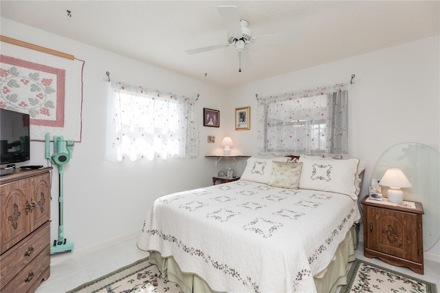 bedroom featuring light tile patterned floors, ceiling fan, and baseboards