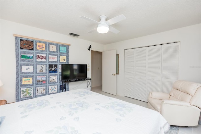 bedroom featuring a textured ceiling, ceiling fan, and a closet