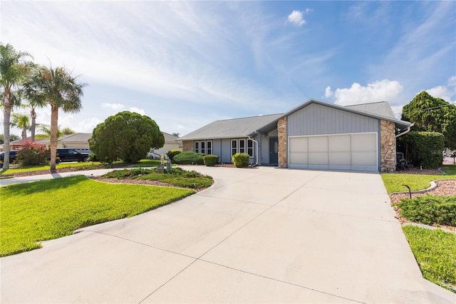 view of front of house featuring concrete driveway, a garage, and a front lawn