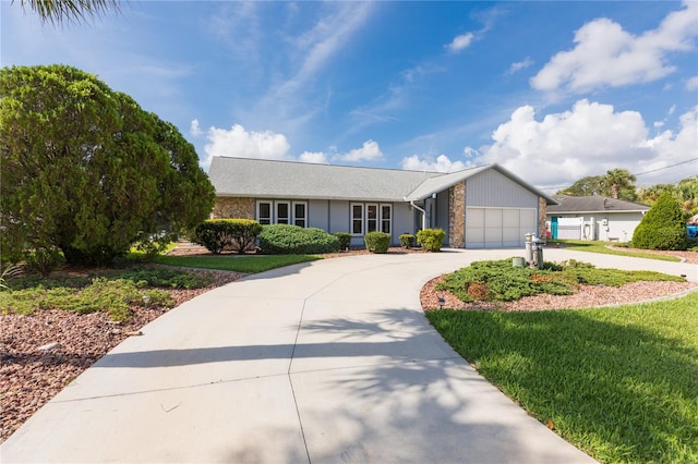 ranch-style house with stone siding, curved driveway, an attached garage, and a front yard