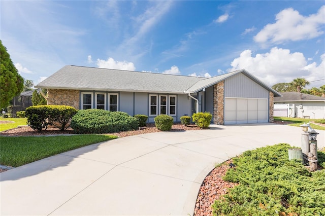 view of front facade with an attached garage, stone siding, and driveway