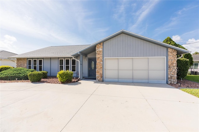 view of front facade with stone siding, driveway, and a garage