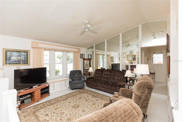 living room with a textured ceiling, ceiling fan, and vaulted ceiling