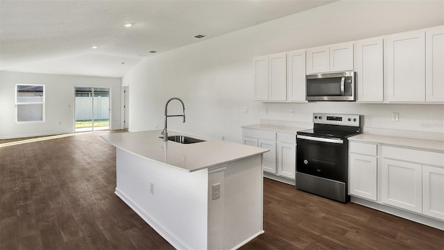 kitchen featuring lofted ceiling, a center island with sink, sink, white cabinetry, and stainless steel appliances