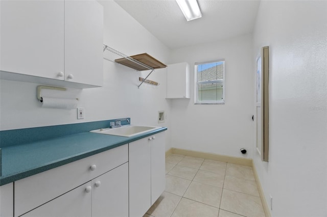 washroom featuring sink, light tile patterned floors, cabinets, washer hookup, and a textured ceiling