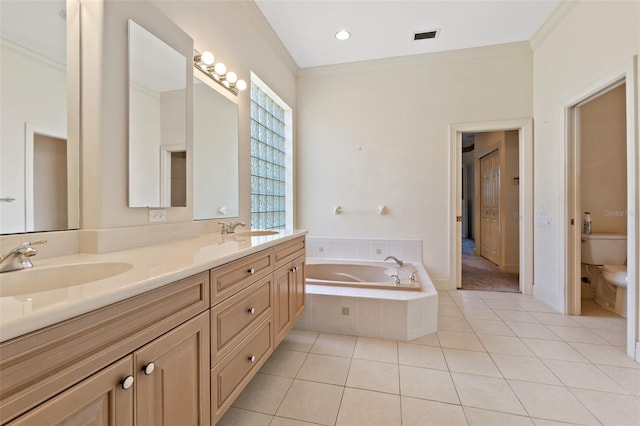 bathroom featuring vanity, a relaxing tiled tub, toilet, crown molding, and tile patterned floors