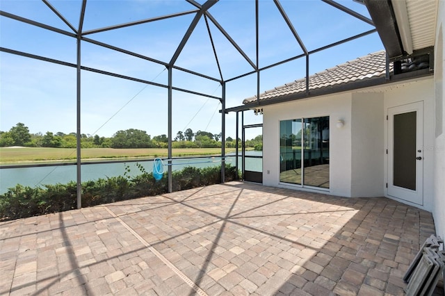 view of patio featuring a water view and a lanai