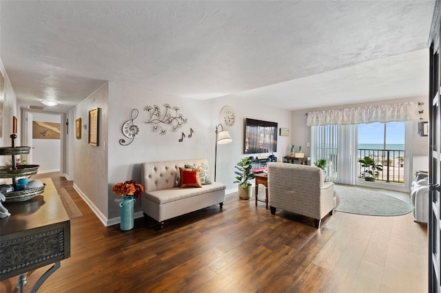 living room featuring dark hardwood / wood-style flooring and a textured ceiling