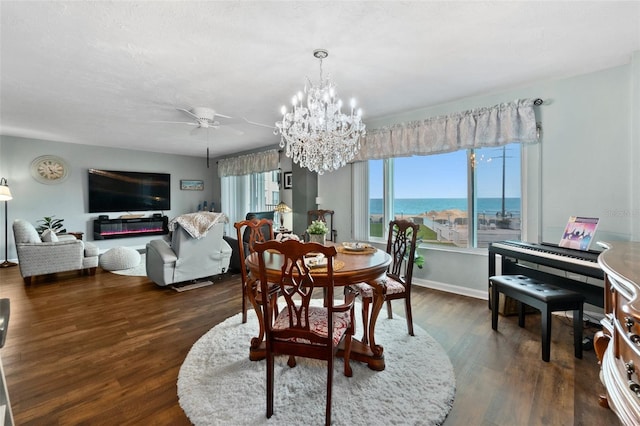 dining area featuring ceiling fan with notable chandelier and dark hardwood / wood-style floors