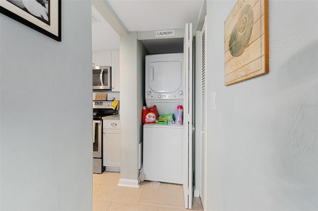 hallway with stacked washing maching and dryer and light tile patterned floors