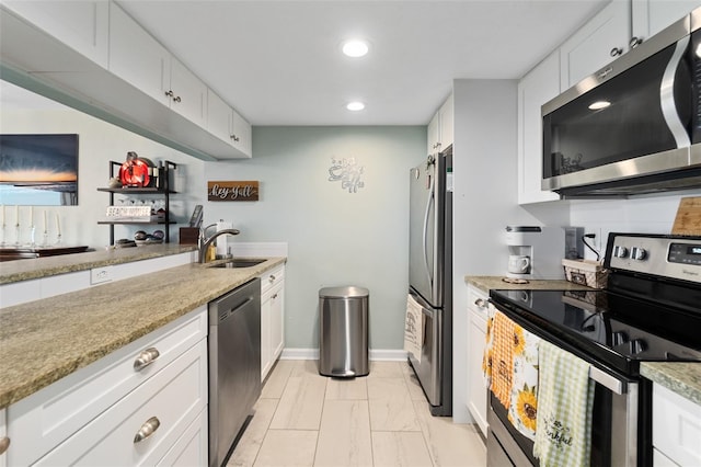 kitchen featuring light stone counters, sink, white cabinets, and stainless steel appliances