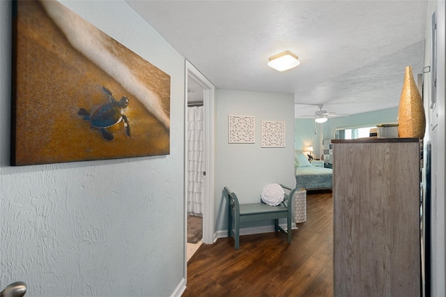 hall with dark hardwood / wood-style flooring and a textured ceiling