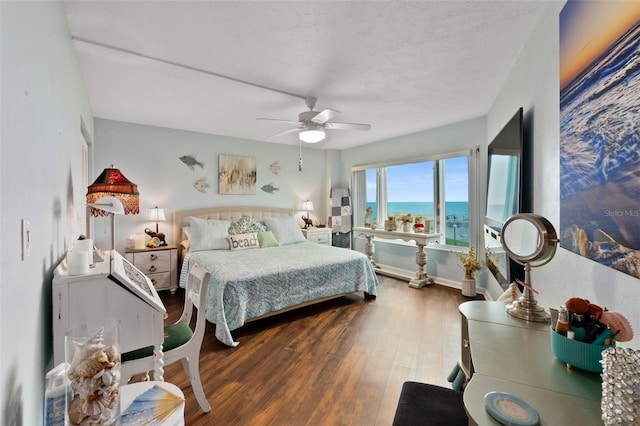 bedroom featuring ceiling fan, wood-type flooring, and a textured ceiling