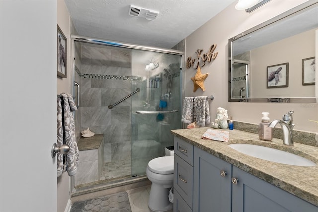 bathroom with an enclosed shower, a textured ceiling, vanity, tile patterned flooring, and toilet