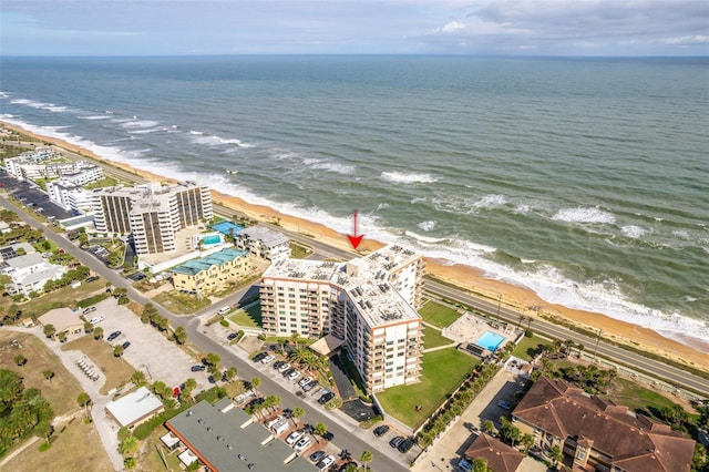 drone / aerial view featuring a water view and a view of the beach