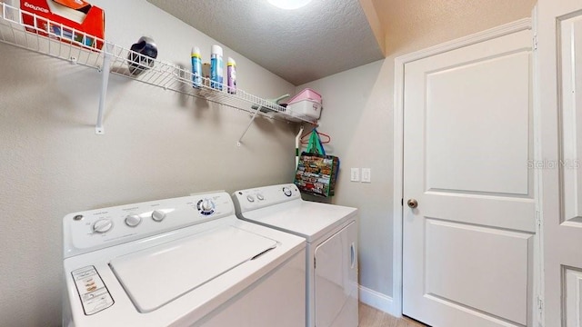 laundry area featuring washer and clothes dryer and a textured ceiling