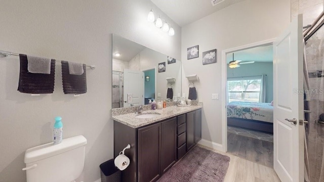 bathroom featuring ceiling fan, toilet, a shower with door, vanity, and hardwood / wood-style flooring