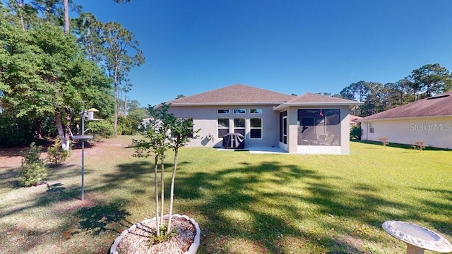 back of house with a sunroom and a lawn