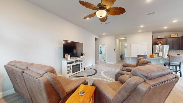 living room featuring ceiling fan and light wood-type flooring