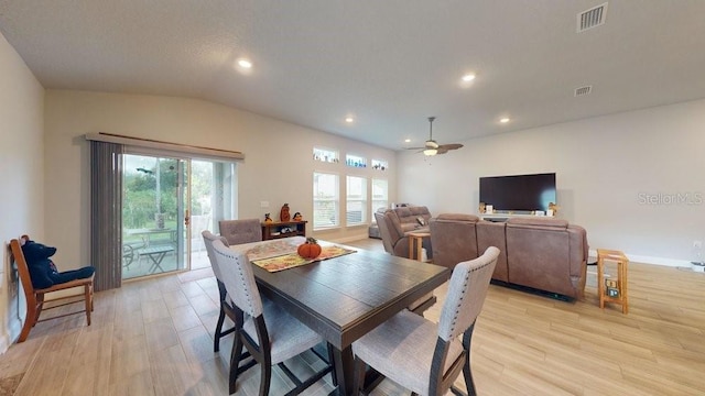 dining space featuring ceiling fan, lofted ceiling, and light hardwood / wood-style flooring