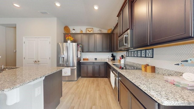 kitchen featuring backsplash, dark brown cabinetry, light stone counters, and appliances with stainless steel finishes