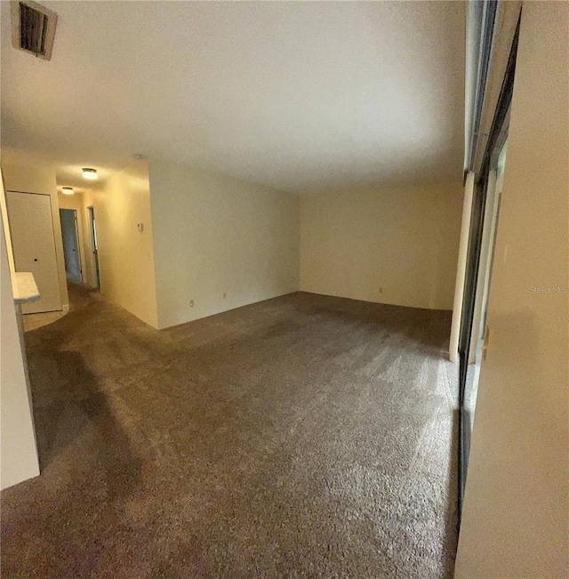 unfurnished room featuring carpet and visible vents