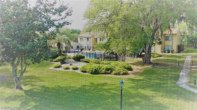 surrounding community with fence and a lawn