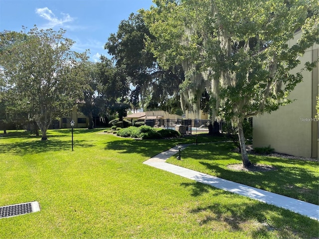 surrounding community with a lawn and fence