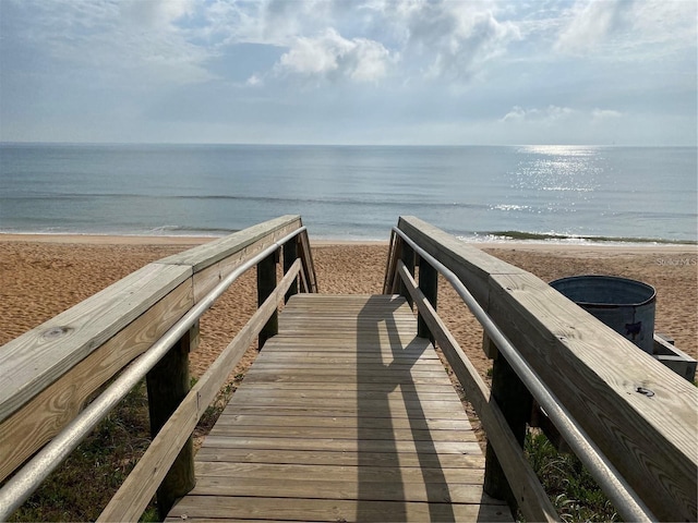 view of home's community featuring a water view and a beach view