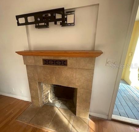 details featuring wood-type flooring and a tile fireplace